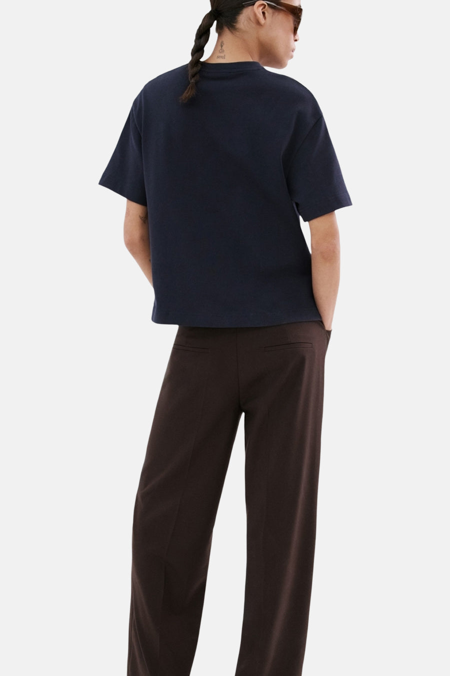 T-shirt bleu de MANGO, manches courtes et coupe carrée, porté avec un pantalon marron à jambes larges.