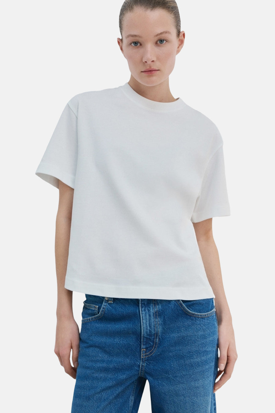 Wit T-shirt van MANGO, korte mouwen, gedragen met een wijde blauwe spijkerbroek, achtergezicht.