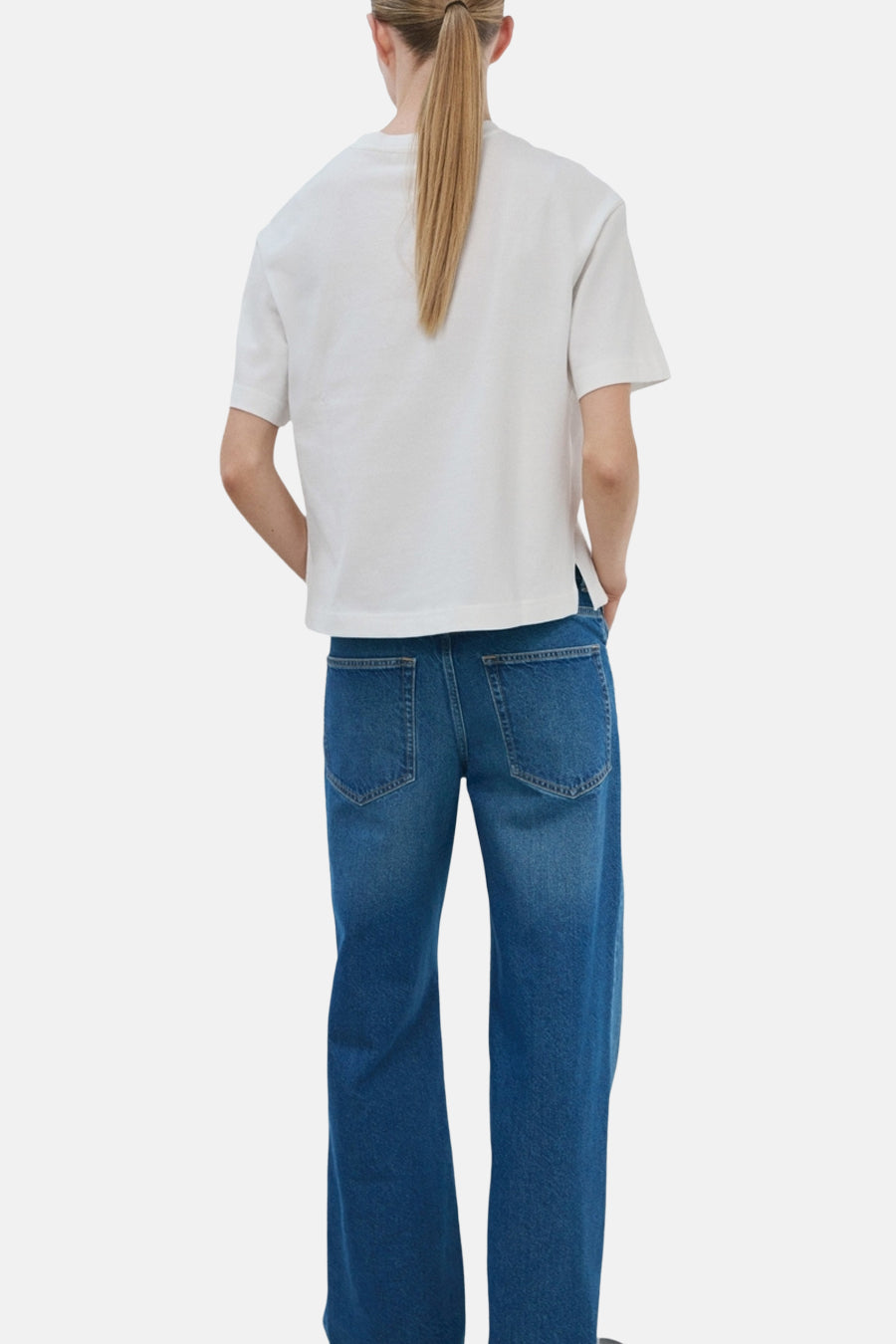 T-shirt blanc de MANGO, manches courtes, porté avec un pantalon en denim bleu large, vue de dos.