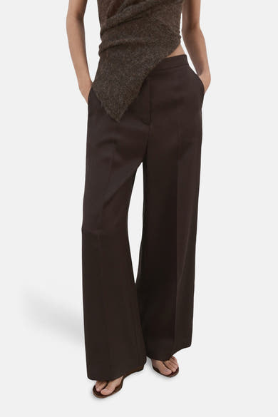 Bruine wijde broek van MANGO, met elastische taille en een wijde pijp die over sandalen valt.