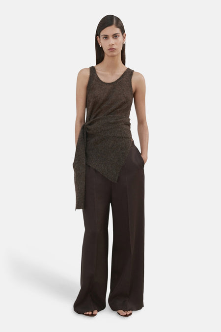 Pantalon brun de MANGO, large et fluide, porté avec un haut sans manches à nouer.
