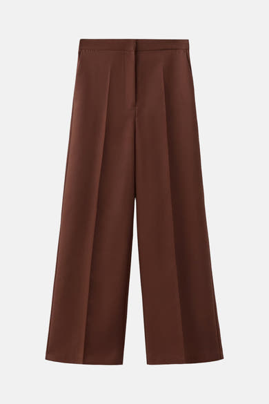 Bruine broek van MANGO, wijde en geplooide pasvorm, op neutrale achtergrond.