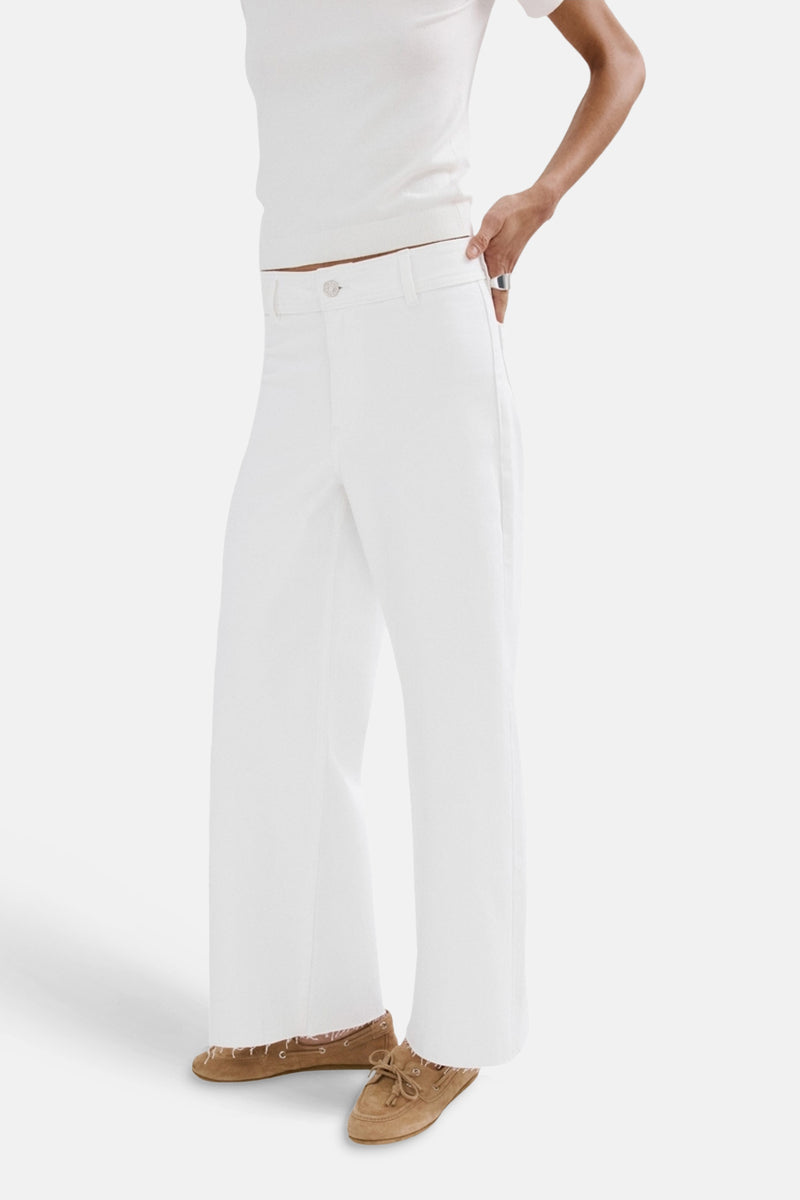 Jean large en denim blanc de MANGO, porté avec un haut blanc et des mocassins en daim marron.