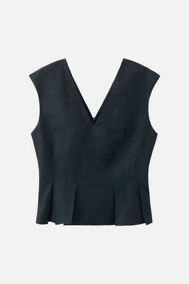 Donkerblauwe mouwloze blouse van MANGO, met een V-hals en plooien bij de taille.