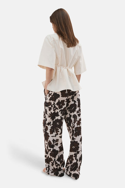 Pantalon fleuri de MANGO, ample et à taille haute, avec motif floral noir et blanc.