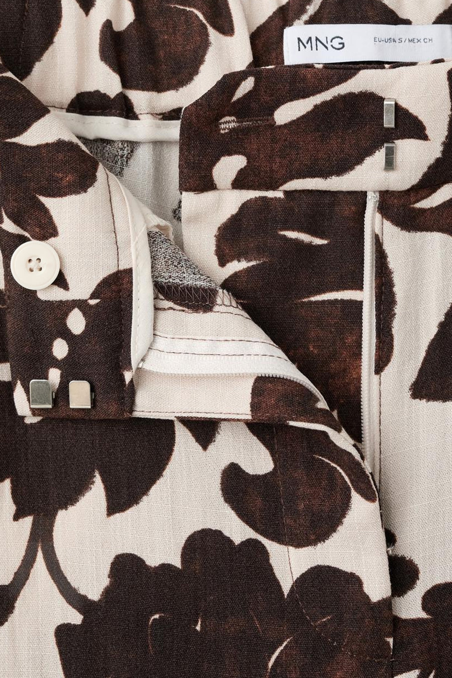 Multikleurige broek van MANGO, met een bruin-witte bloemenprint en ritssluiting.
