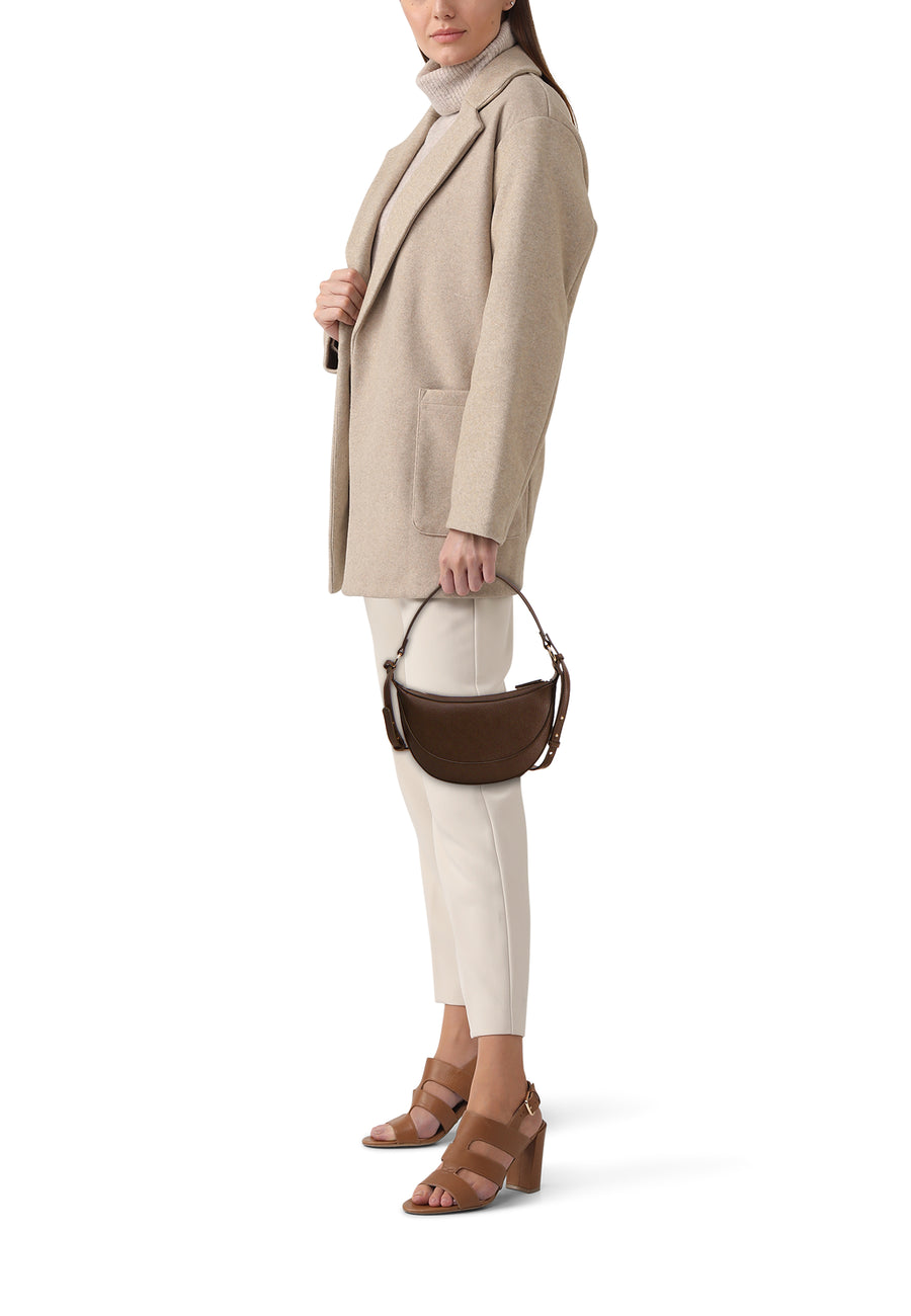 Kaki schoudertas van MANGO, gedragen met een beige jas, gebroken witte broek en bruine sandalen met hak.