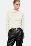Ecru blouse met lange mouwen van MANGO, gedragen met een zwarte flared broek van imitatieleer.