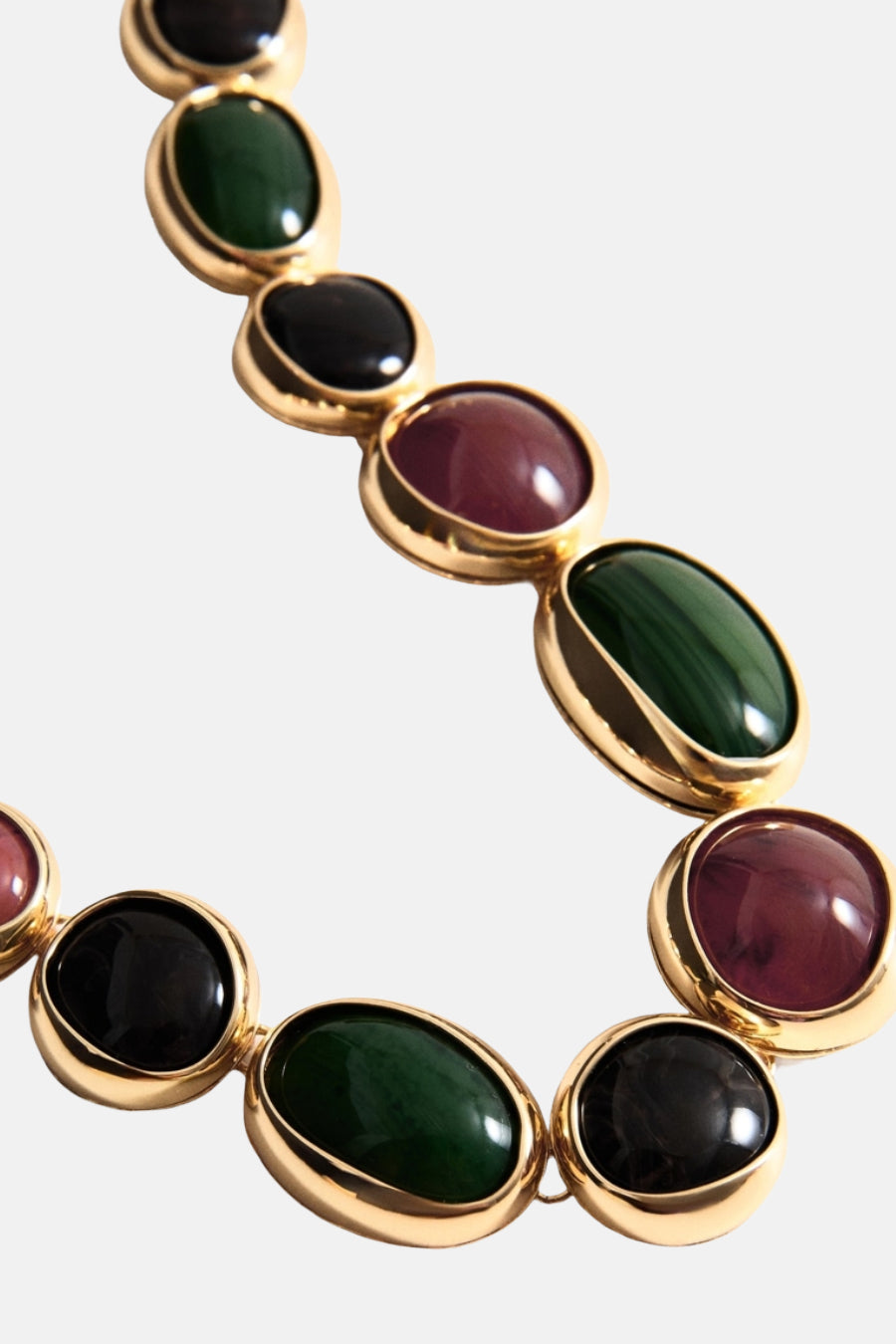 MANGO halsketting met een gouden oor en meerdere kleurige steenen.