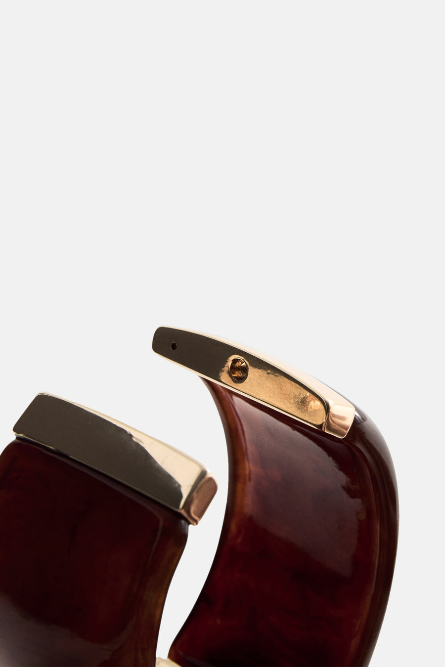Bracelet marron, par MANGO, avec des détails dorés et une finition brillante.