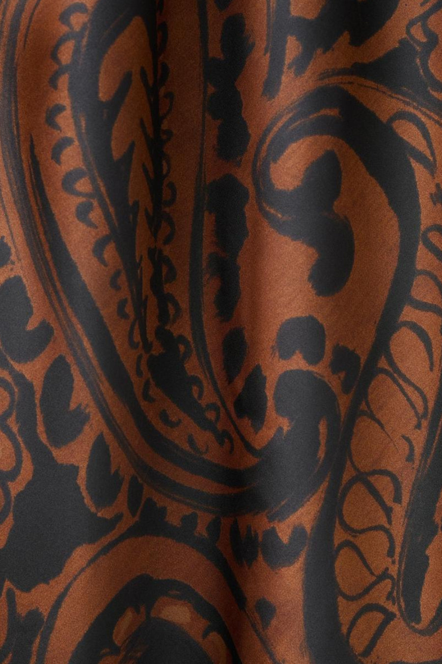 Multikleurenjurk van MANGO, met een zwart en bruin paisleypatroon op een licht gekreukte stof.