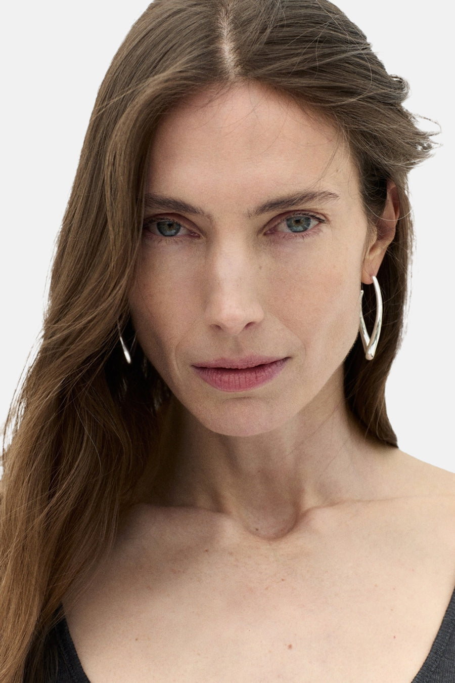 Boucles d'oreilles argentées de MANGO, portées par un mannequin aux cheveux longs et châtains.