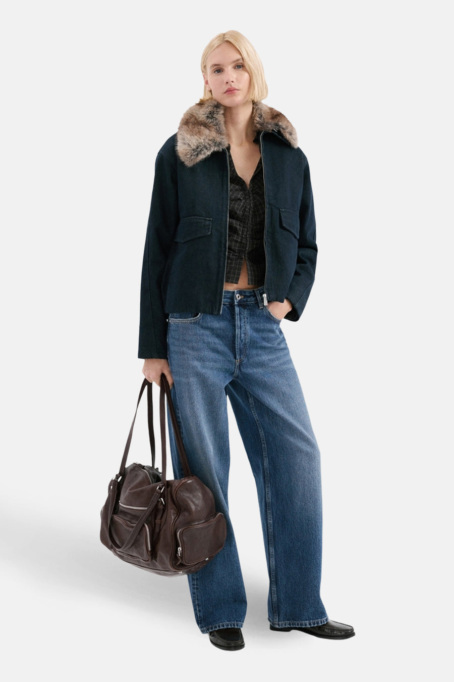 Jean droit en denim bleu moyen de MANGO, porté avec un blouson et un sac marron.

