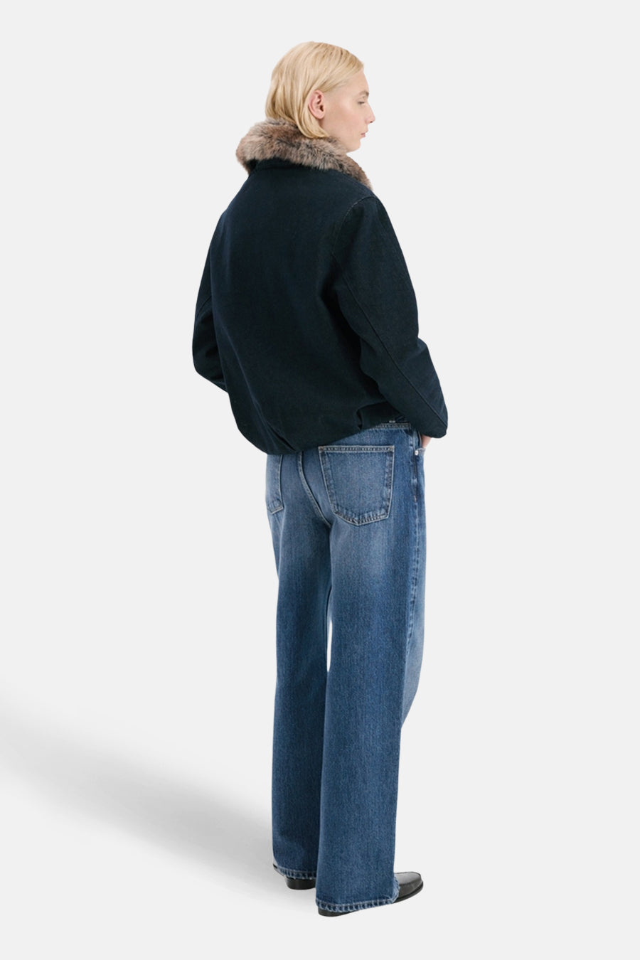 Jean droit en denim bleu moyen de MANGO, porté avec un blouson et des chaussures noires.