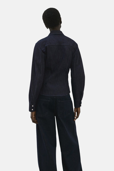 Chemise à manches longues en denim bleu foncé de MANGO, vue de dos, portée avec un pantalon assorti.