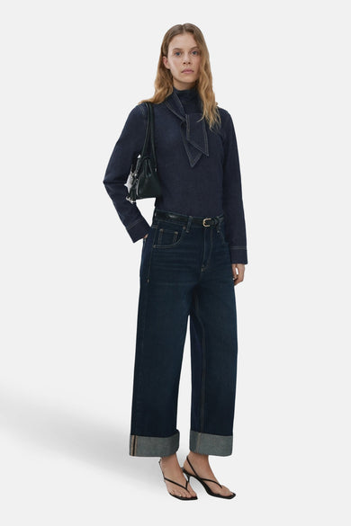 Chemisier denim à manches longues par MANGO, avec col montant à nœud et finitions surpiquées.