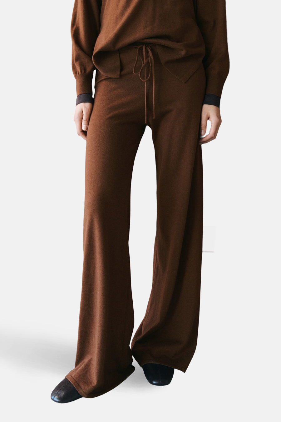 Bruine broek van MANGO, wijde pasvorm en uitlopende pijpen, gedragen met een bijpassend topje.