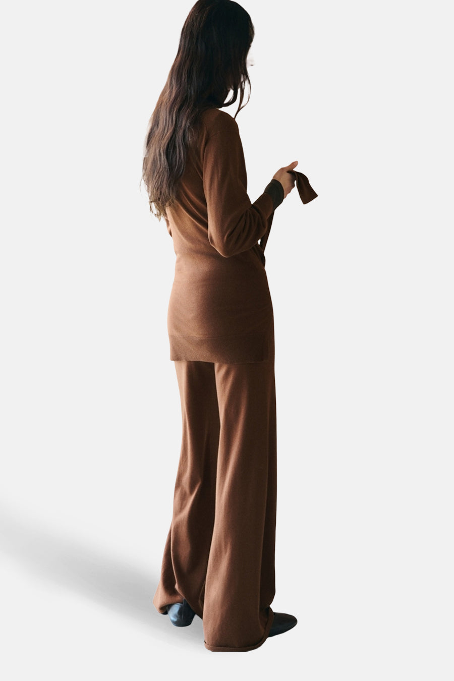 Pantalon brun de MANGO, coupe ample et jambes évasées, porté avec un haut assorti.