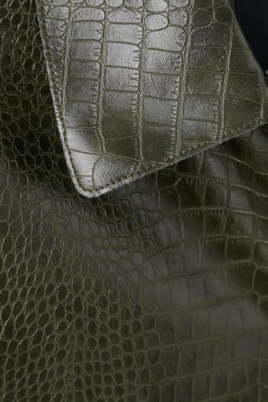 Korte kaki jas in krokodillenlook van MANGO, textuurdetail bij de kraag.