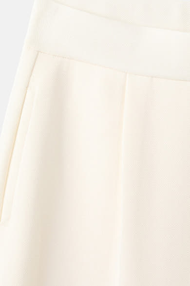 Jogging beige de MANGO, avec une poche visible et une texture subtile en gros plan.
