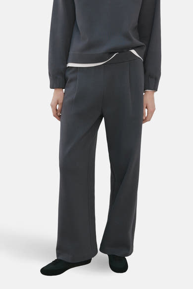 Blauwe joggingbroek van MANGO, met een losse en comfortabele pasvorm, gedragen met een lichtgrijze trui.