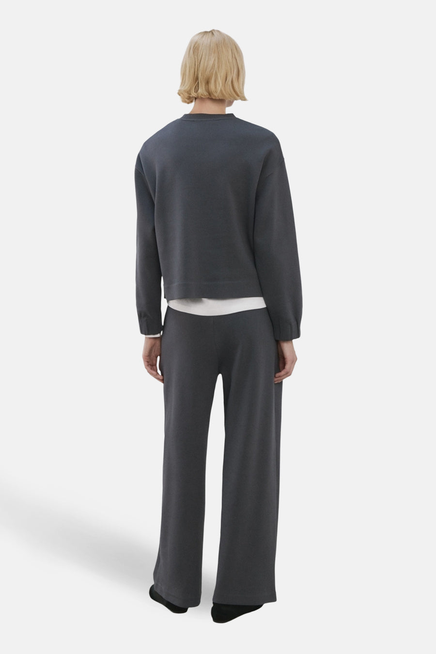 Jogging bleu de MANGO, avec une coupe ample et confortable, porté avec un pull gris clair.