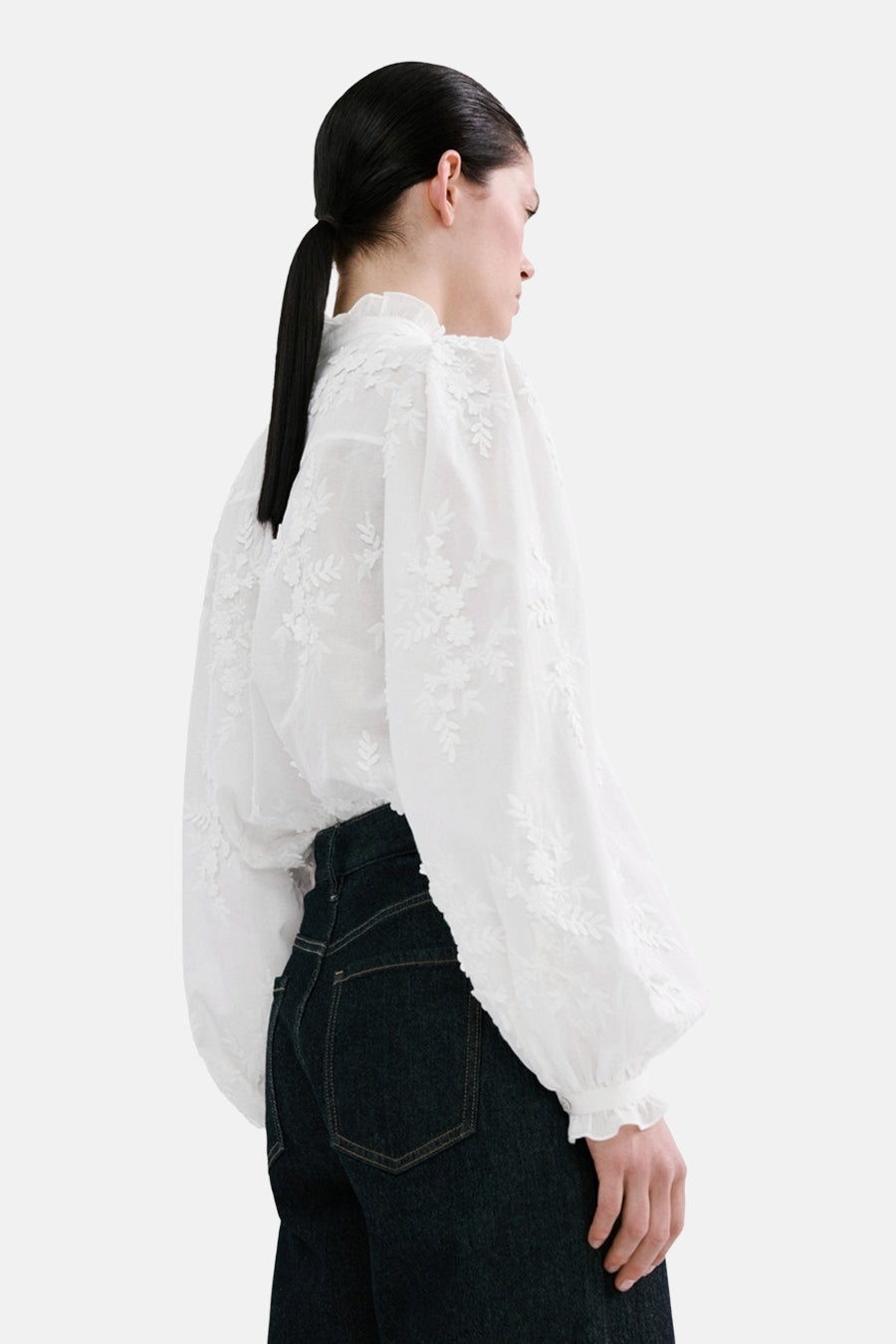 Blouse à manches longues blanche de MANGO avec broderie florale, manches bouffantes et détails à volants.