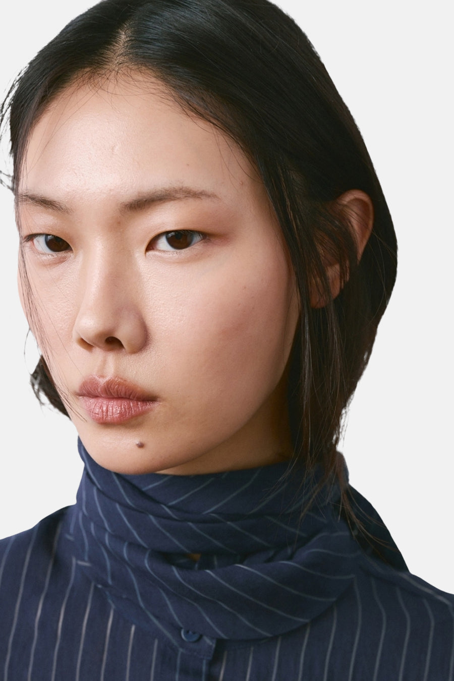 Blauwe blouse met lange mouwen van MANGO, verticale strepen op een marineblauwe achtergrond, gedragen door een model.