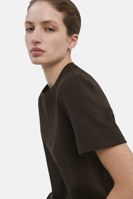 T-shirt uni à manches courtes brun de MANGO, porté par un mannequin avec un teint de peau clair.