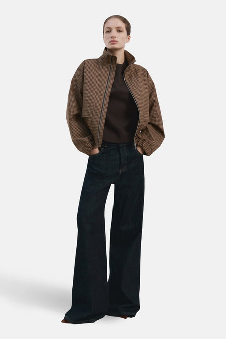 T-shirt uni à manches courtes brun de MANGO, porté avec une veste à carreaux et un jean ample.