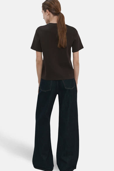 T-shirt à manches courtes brun de MANGO, vue arrière avec un pantalon large bleu foncé.