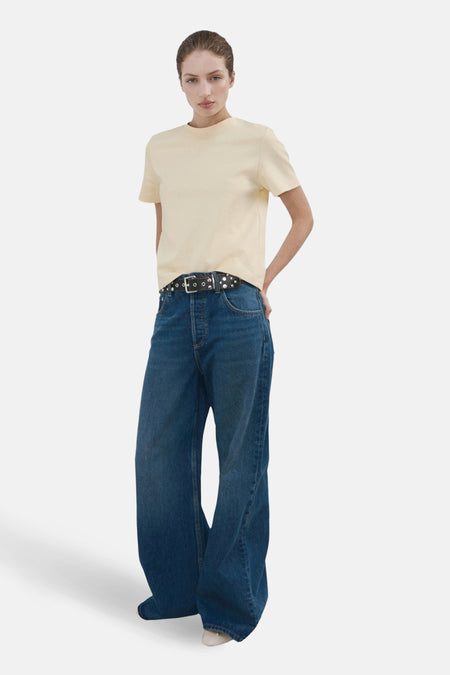 Gedragen met een wijde jeans en een riem met studs, een gele T-shirt met korte mouwen van MANGO.