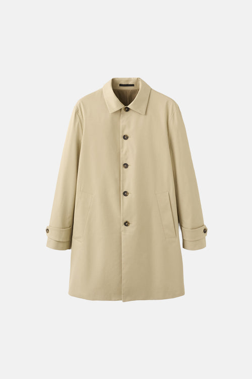 Veste longue beige de MANGO, avec col à revers, boutonnage sur le devant et poches latérales.