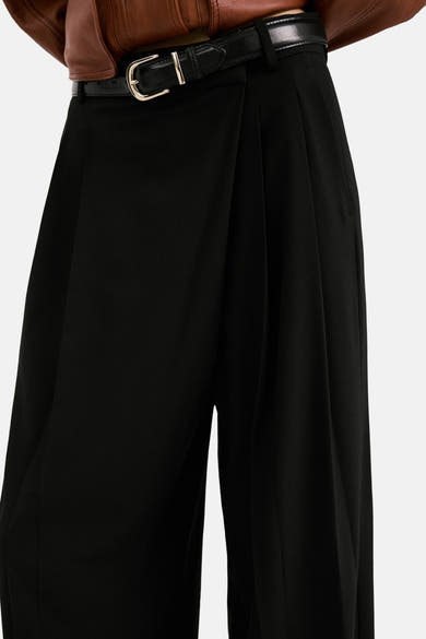 Zwarte broek van MANGO, met zwarte riem en gouden gesp, losse en elegante pasvorm.