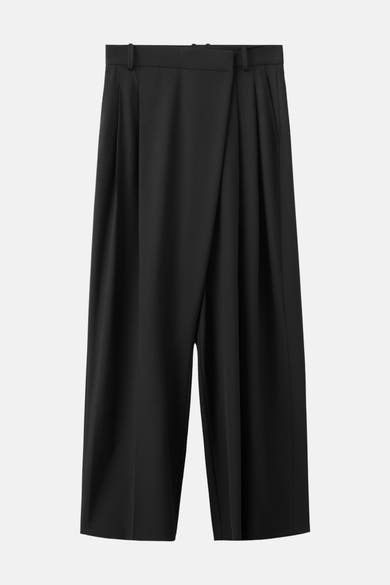 Pantalon noir de MANGO avec une coupe ample et des plis à l'avant.