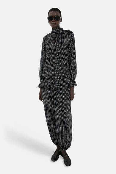 Chemisier noir à pois, de MANGO, avec col montant, manches longues et ourlets froncés.