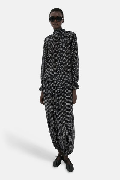 Chemisier noir à pois, de MANGO, avec col montant, manches longues et ourlets froncés.