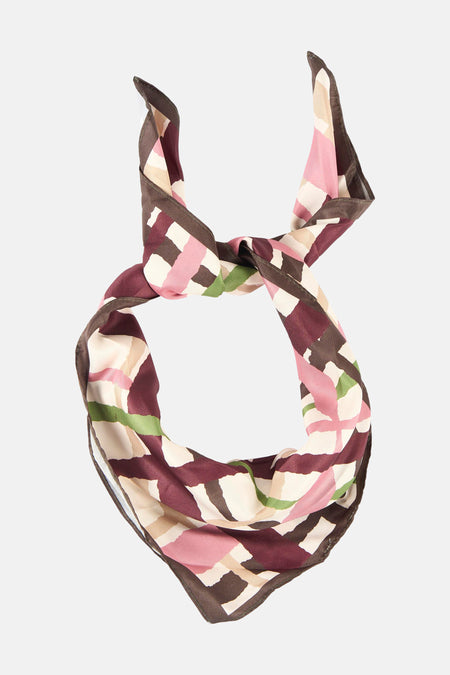 Foulard multicolore de MANGO, noué avec un motif géométrique et des rayures dans les tons rose, marron et vert.
