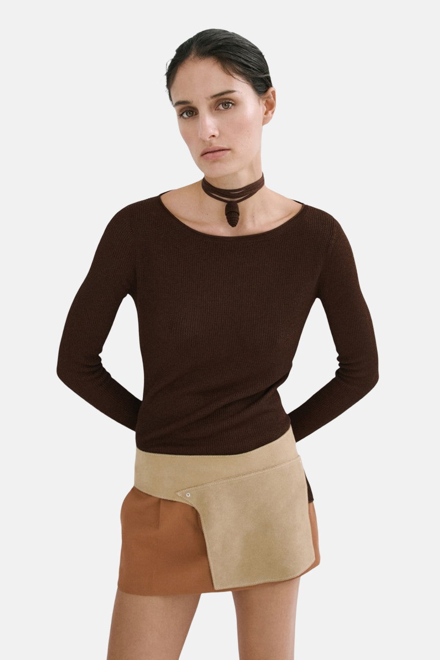 Pull long à manches brun côtelé de MANGO, col bateau, avec un collier ras du cou et une jupe portefeuille bicolore.