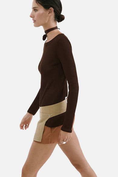 Pull brun à col O de MANGO en maille côtelée, manches longues, porté de profil avec un choker assorti.