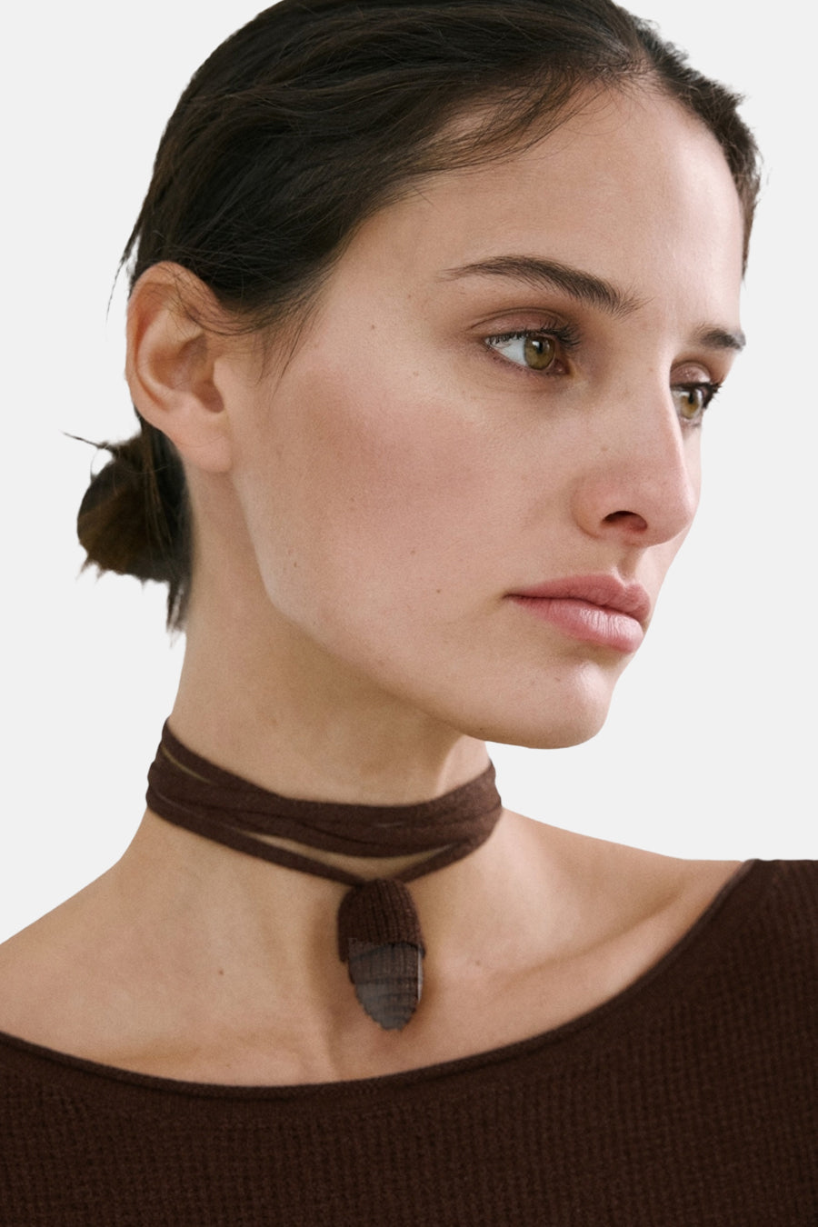 Pull brun col rond de MANGO, porté avec un collier ras-de-cou marron.