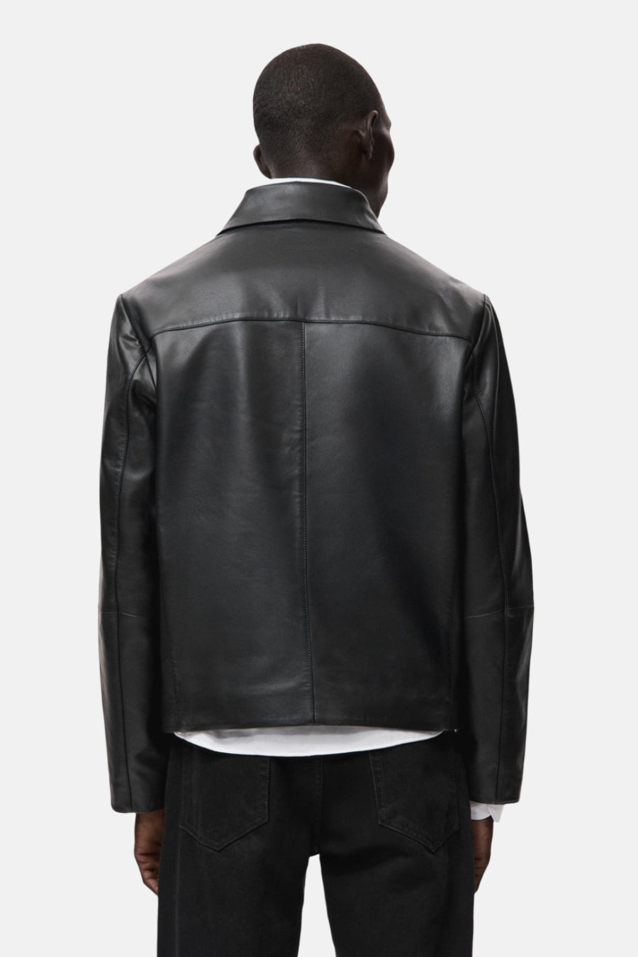 Veste courte noire en cuir by MANGO, vue de dos, avec un col chemise et des poches discrètes.
