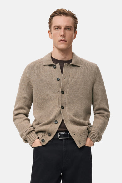 Beige gilet van MANGO, achterkant, gedragen met een zwarte broek.
