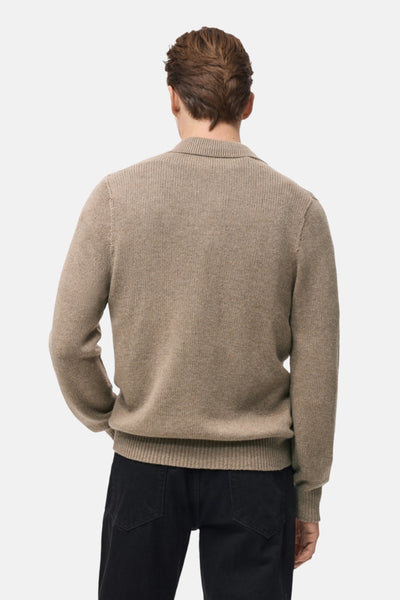 Gilet beige de MANGO, vue arrière, porté avec un pantalon noir.
