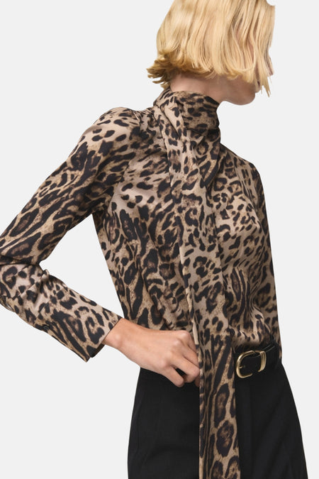 Chemisier à manches longues multicolore de MANGO, avec un motif léopard et une ceinture noire.
