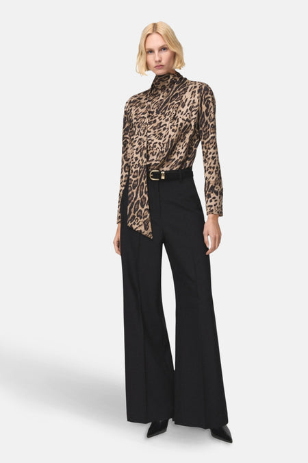 Chemisier multicolore à manches longues de MANGO, imprimé léopard, porté avec un pantalon taille haute noir et une ceinture dorée.