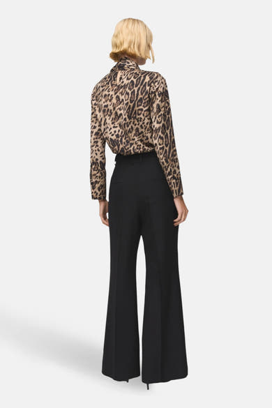 Chemisier à manches longues multicolore de MANGO, à imprimé léopard, porté avec un pantalon noir à taille haute.