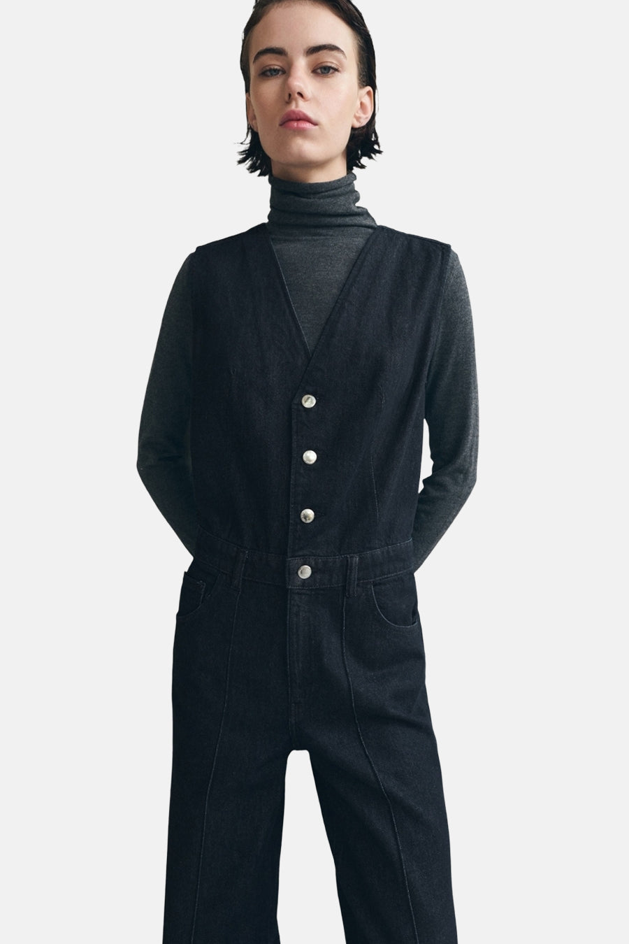 Marineblauwe denim overall van MANGO, gedragen over een grijze coltrui.