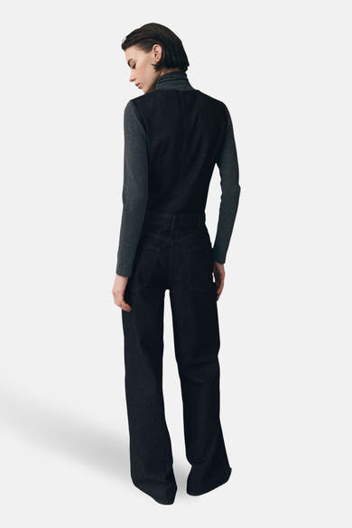Combinaison denim de MANGO, vue de dos, portée sur un col roulé gris à manches longues.