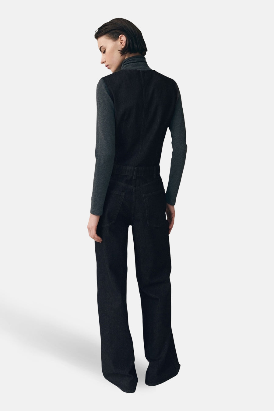 Combinaison denim de MANGO, vue de dos, portée sur un col roulé gris à manches longues.
